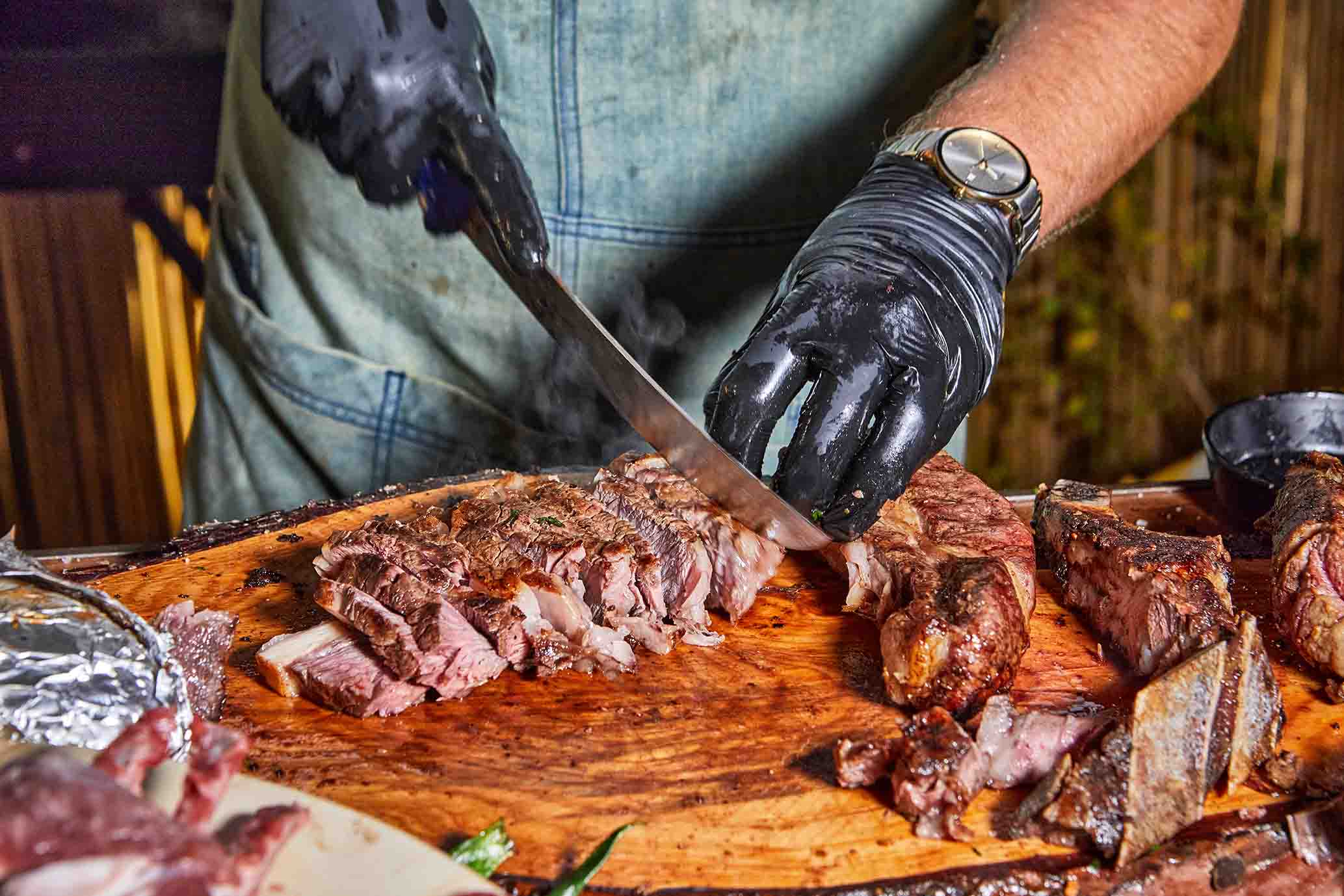 Mãos trabalhando no corte de carne